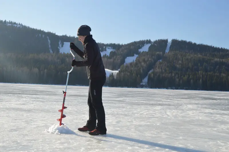 ice fishing on a frozen lake in finland